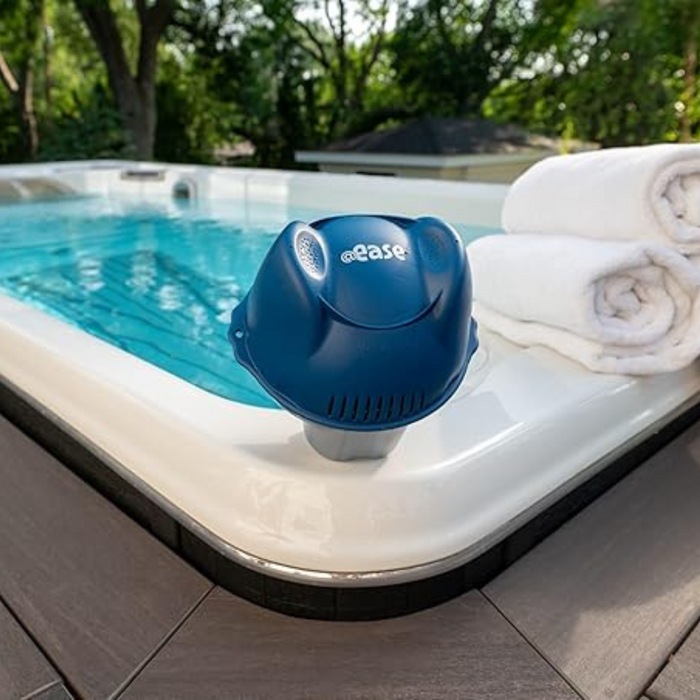 FROG @ease Swim Spa Sanitizing System with the "Ease" logo, utilizing SmartChlor Technology, next to rolled white towels on a wooden deck.