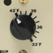 Close-up of the Intermatic PF1103 Freeze Protector dial on a beige panel, set between 36°F and 39°F, with temperature markings from 33°F to 42°F, ensuring precise automatic control.