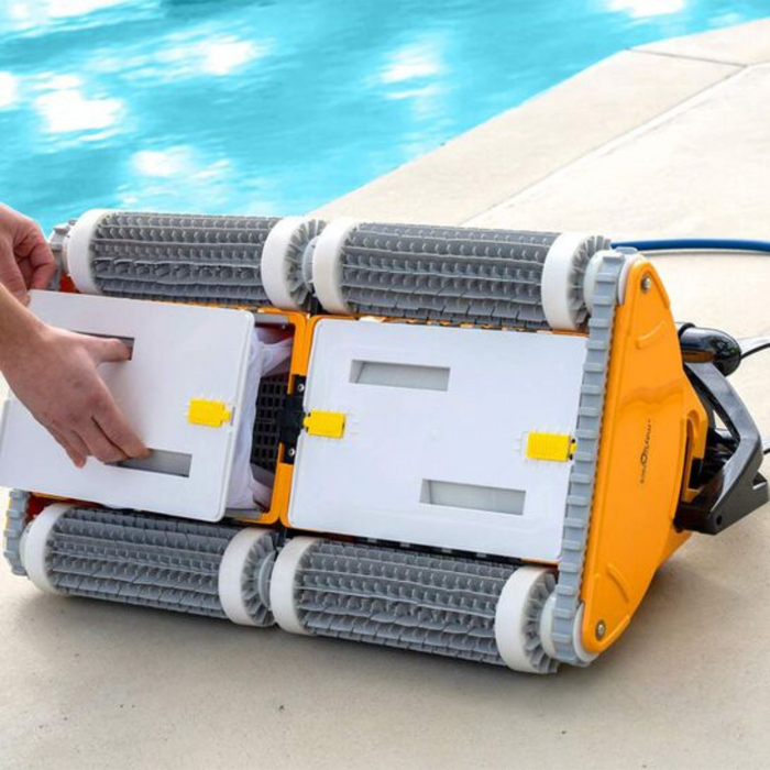 A person opens a Maytronics Dolphin Wave 120 Commercial Robotic Pool Cleaner (model number: 9999359-W120) with its yellow and gray components, positioned near the edge of a swimming pool.