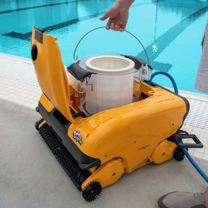 A person operates the Maytronics Dolphin Wave 140 Commercial Robotic Pool Cleaner 99997140-US, a yellow robotic pool cleaner recognized for its heavy-duty scrubbing capabilities, near a swimming pool.