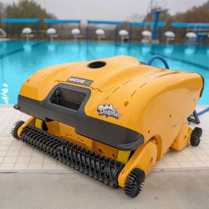 The Maytronics Dolphin Wave 140 Commercial Robotic Pool Cleaner 99997140-US, a yellow robot from Maytronics, sits on the edge of a swimming pool, ready for some heavy-duty scrubbing.