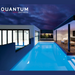 Modern house with a lit swimming pool at night, featuring an outdoor seating area and large glass windows. The Spa Electrics QUANTUM WN Series 6" LED Pool Lights Q6 ensures a mesmerizing glow from the underwater high-intensity ceramic light engine. "Quantum WN Series" text.