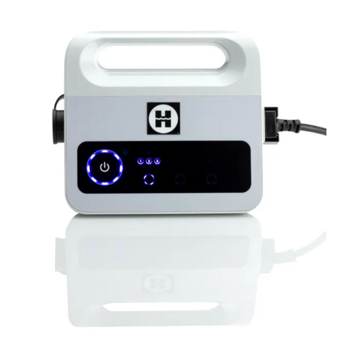 A white Hayward R110 Robotic Cleaner with a handle, control panel, and illuminated power button, plugged into a power source. Featuring smart navigation technology similar to robotic vacuums, it ensures efficient and user-friendly operation for pools up to 33 feet.