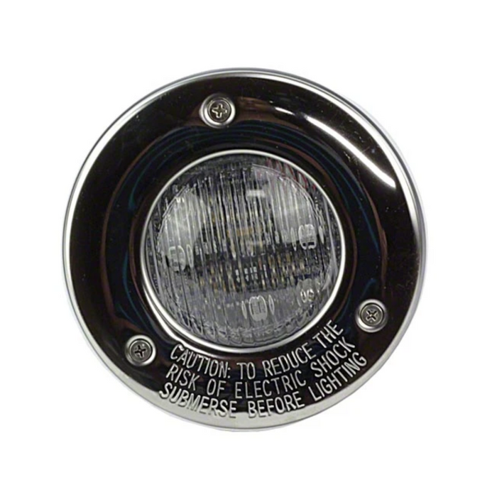 Close-up of a round underwater pool light featuring a cautionary label about submersing before lighting to reduce electric shock risk. The Hayward W3SP0535SLED100 ColorLogic 4.0 LED Spa Light with a 100' cord and stainless trim ensures vibrant and safe pool lighting.